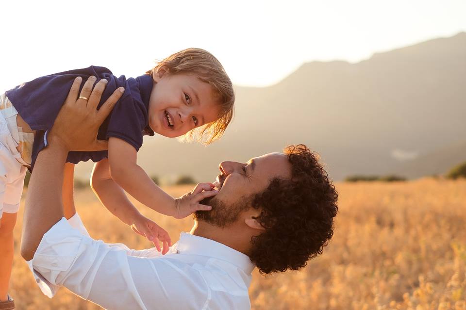 Pai ergue o filho para o alto