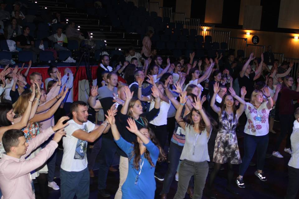 Jovens dançam em momento de louvor