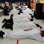 Seminaristas prostrados ao chão durante a oração dos vínculos