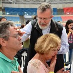 Pe. João Henrique impõe as mãos sobre as pessoas