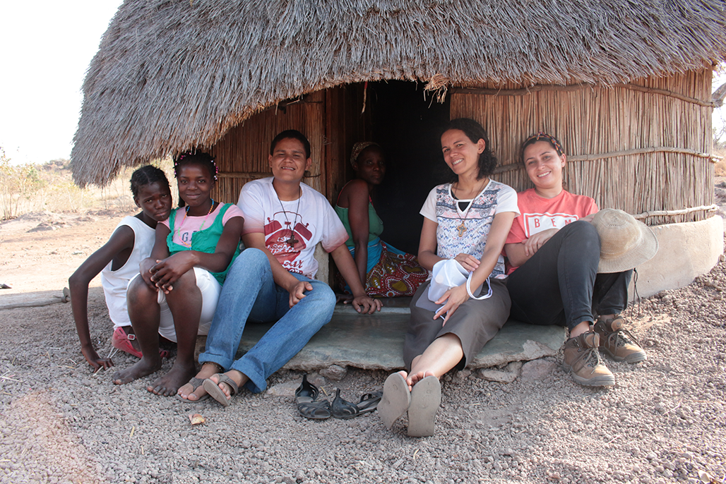 Missionários em numa aldeia de Moçambique na entrada de uma casinha de palha