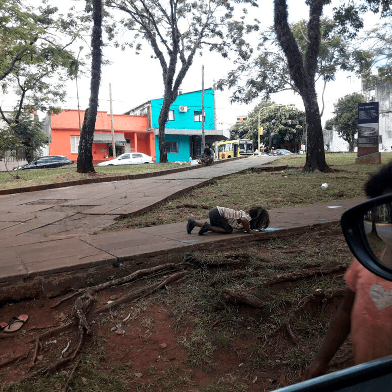 Criança indígena bebe água em poça