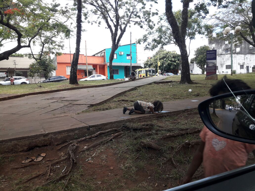 Criança indígena bebe água em poça