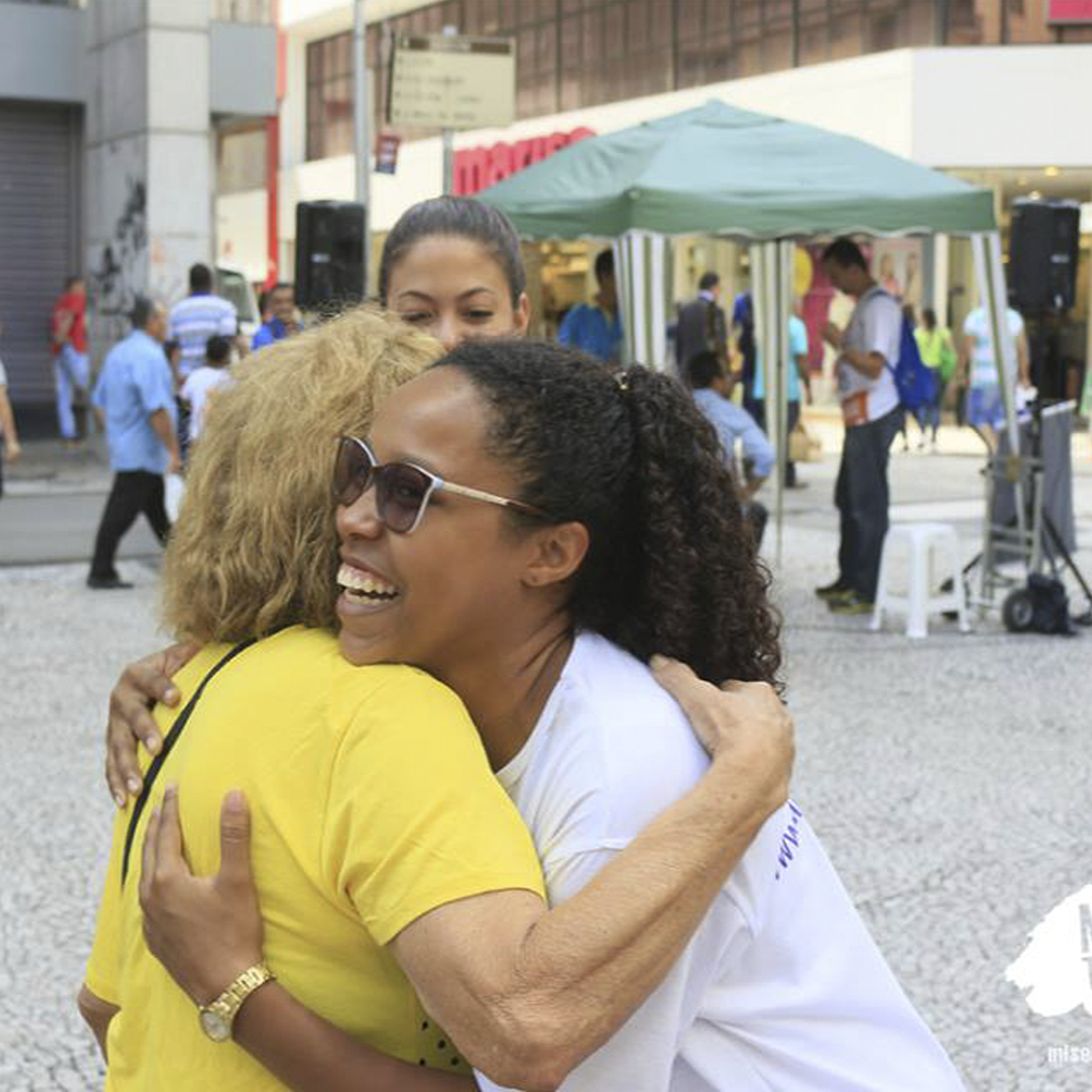 Missionária abraça uma senhora na Praça do Patriarca