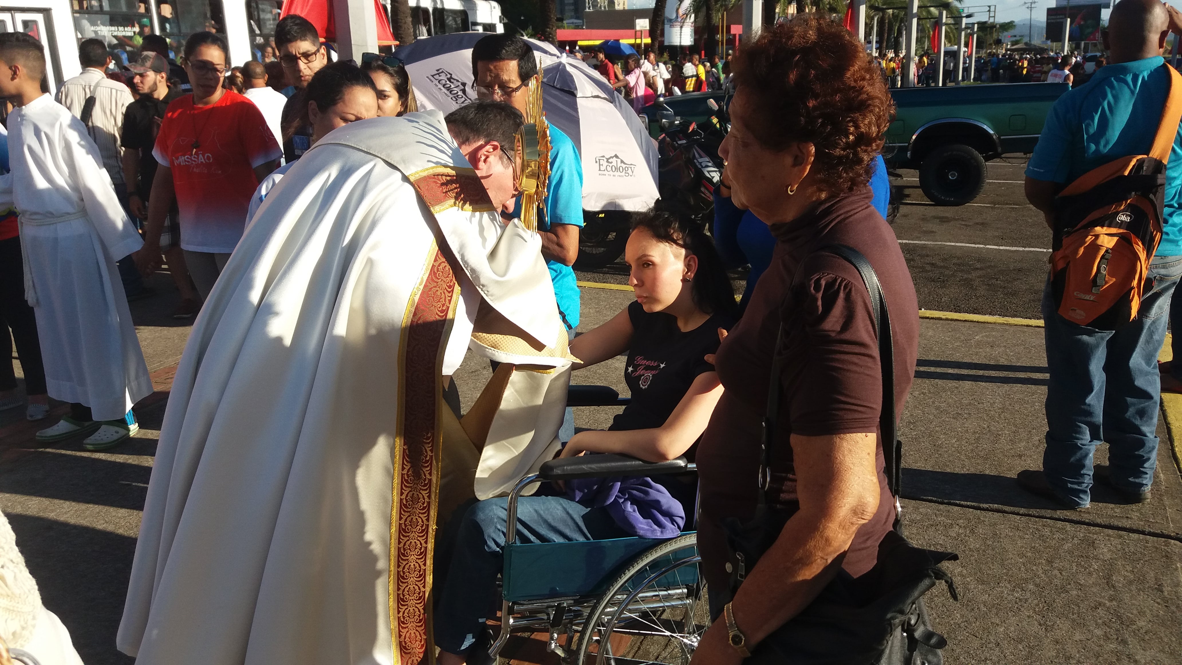 Padre leva o Santíssimo até uma cadeirante