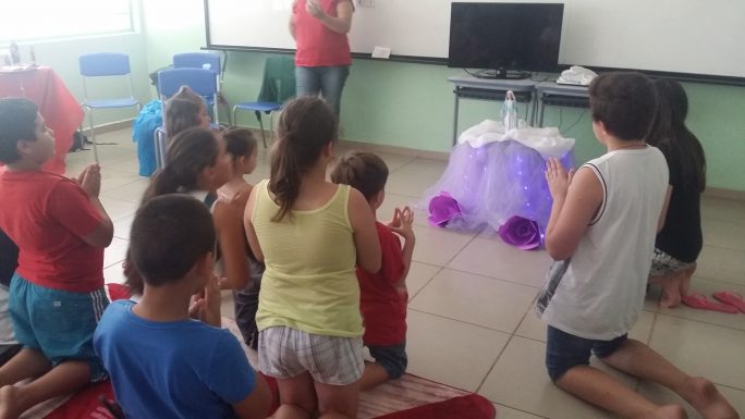 Crianças oram em frente da imagem de Nossa Senhora