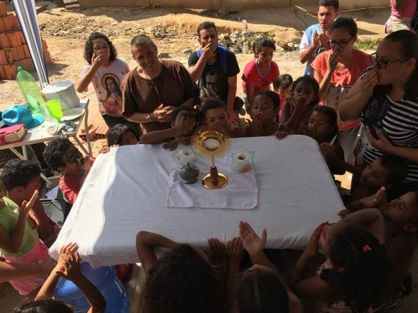 Crianças adoram a Cristo na eucaristia em missão São Felipe Neri