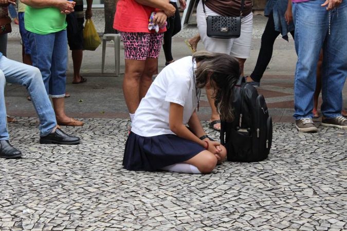 Estudante uniformizada adora Jesus Eucarístico