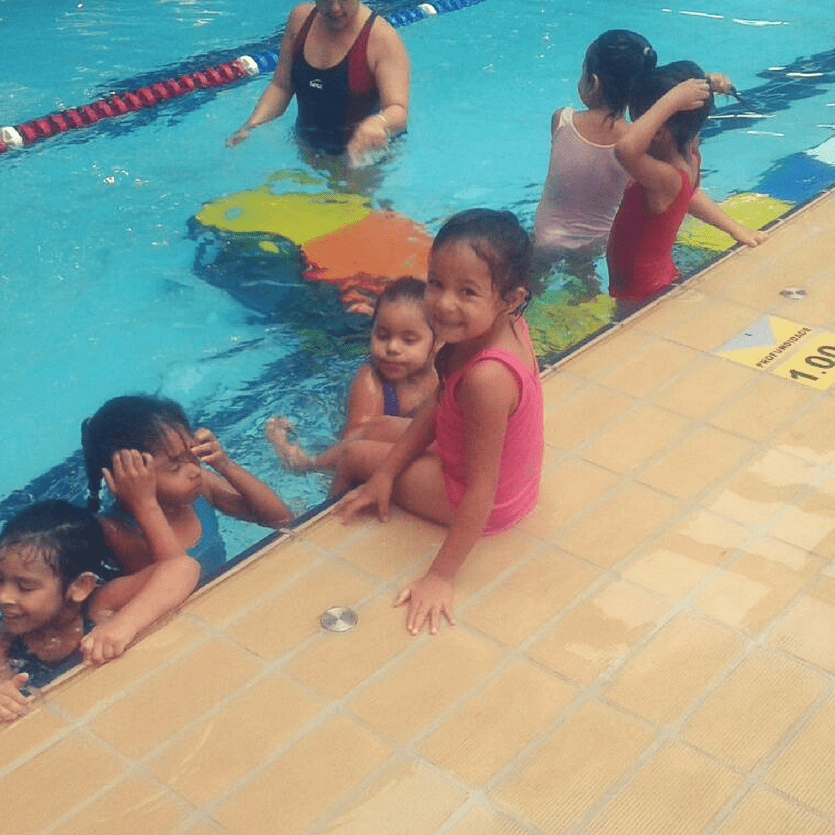 Menina sorri na beira da piscina
