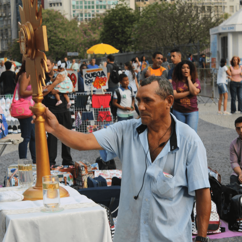 Homem reza em frente ao Santíssimo em plena praça