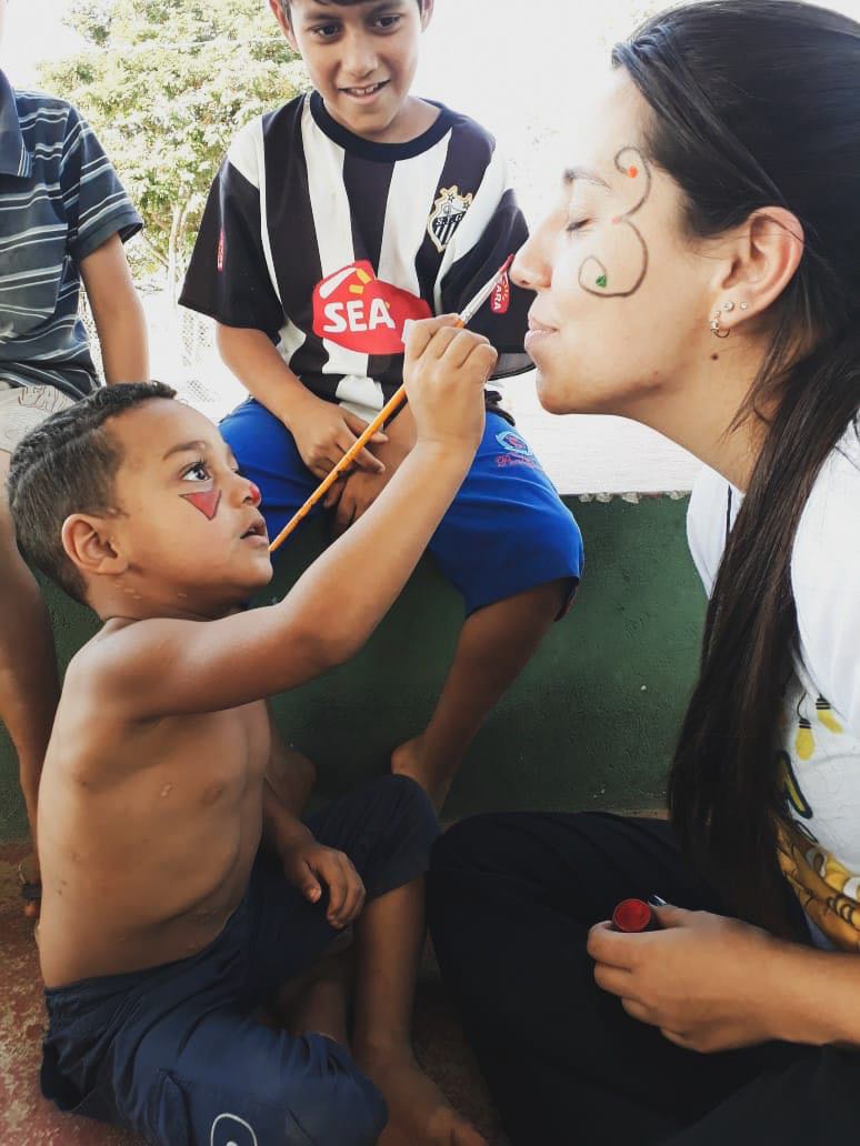 Criança pinta rosto de garota