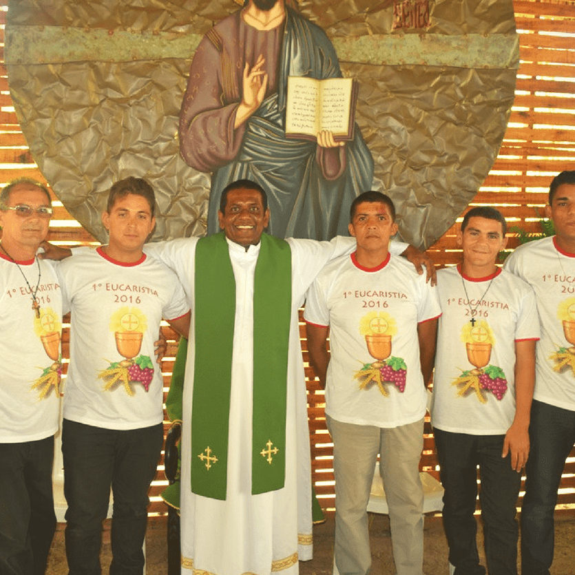 Padre com acolhidos que receberam a primeira eucaristia