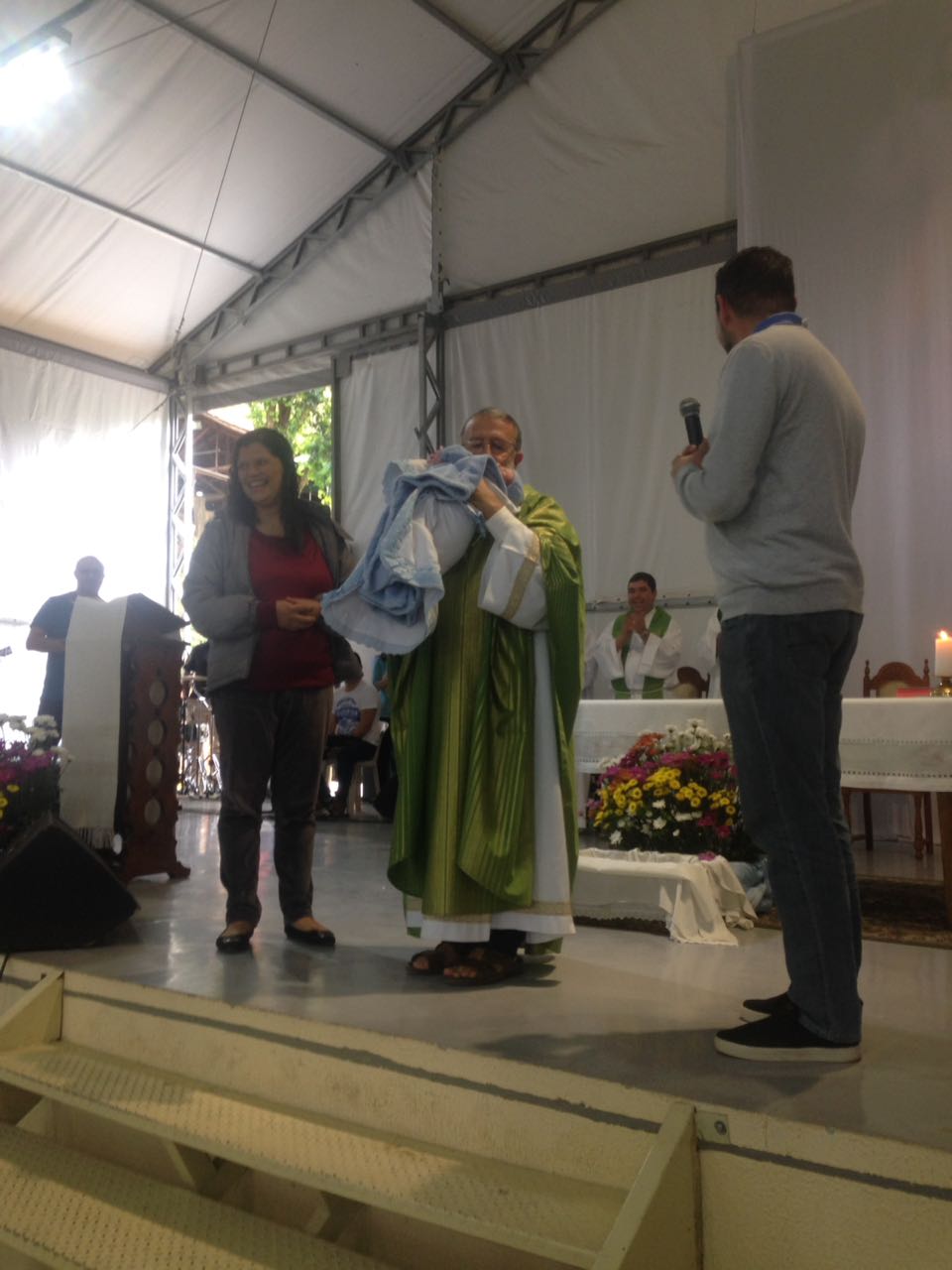 Padre João Henrique apresenta à assembleia um recém nascido.