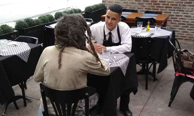 Garçon do Benvindo conversa com homem em situação de rua.