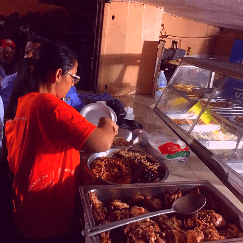 Voluntária serve alimentos