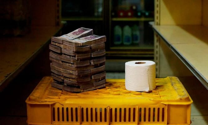 Pilha de bolívares para comprar um rolo de papel higiênico