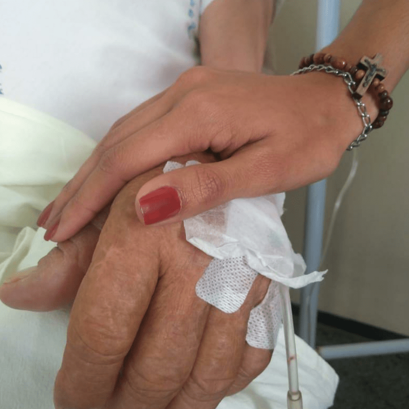 missionária toca na mão de doente