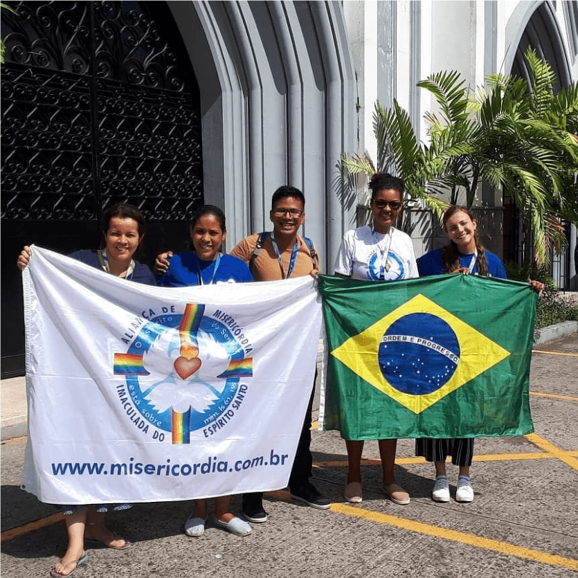 missionários seguram a bandeira do Brasil