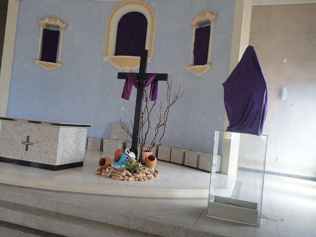 Imagens cobertas com pano roxo em igreja.