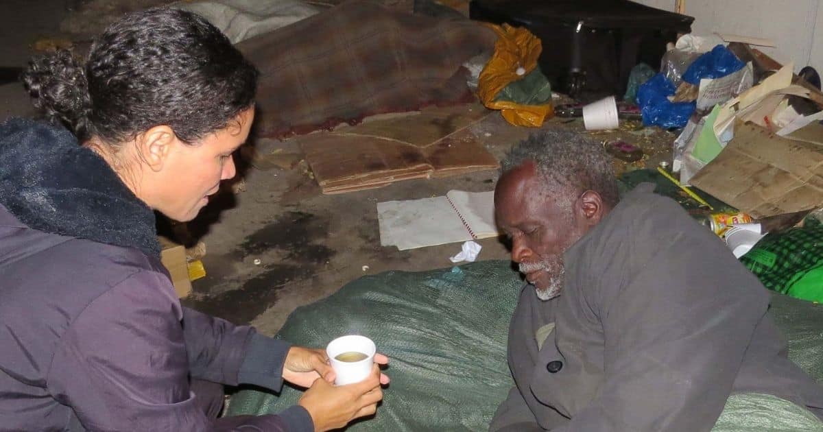 Missionária entrega café a morador de rua em Moçambique.