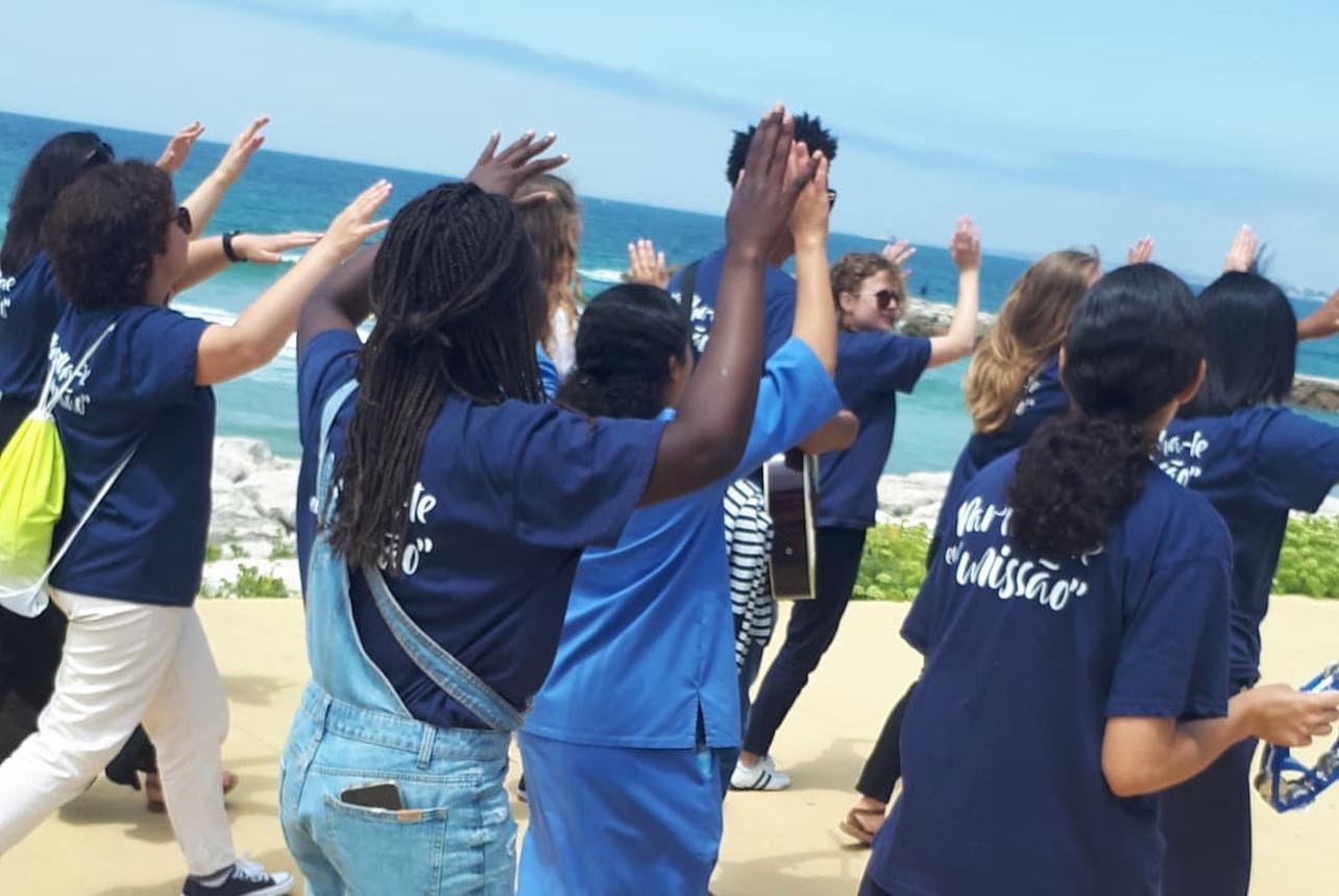 Jovens cantam na orla da praia da Caparica.