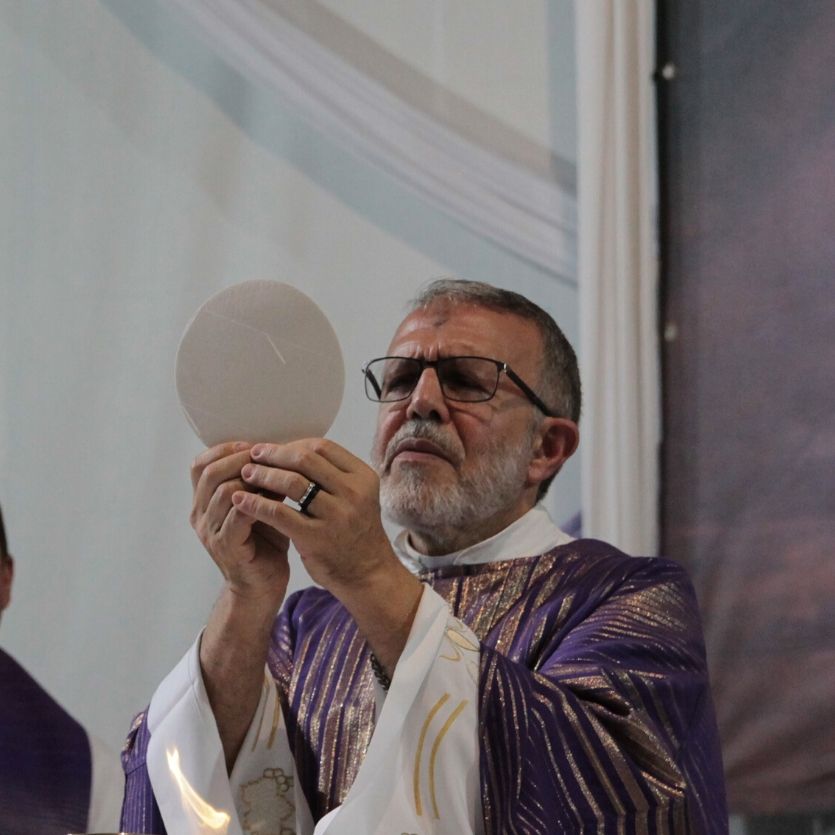 Padre João Henrique consagra a hóstia durante a missa