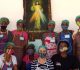 Mulheres de Moçambique em foto com o quadro de Jesus Misericordioso atrás