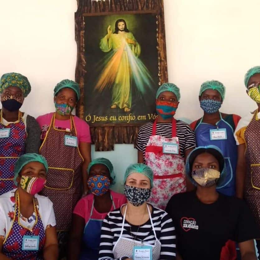 Mulheres de Moçambique em foto com o quadro de Jesus Misericordioso atrás