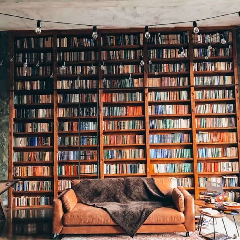 Biblioteca com um sofá marrom